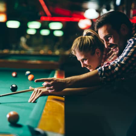 Couple playing billiards