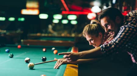 Couple playing billiards