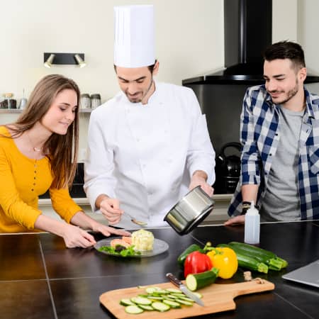 Private Chef Giving Cooking Lessons to Couple