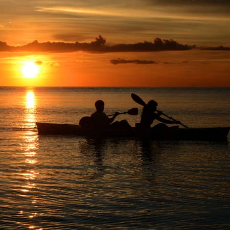 Couple kayaking at sunset