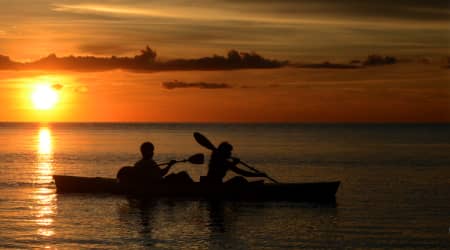 Couple kayaking at sunset