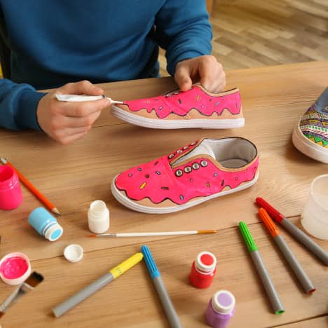 Man Customizing Sneakers with Watermelon Pattern