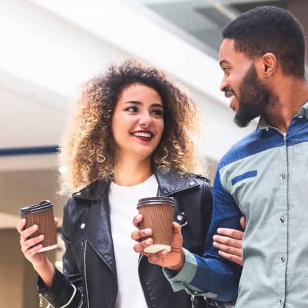 Couple Walking in Shopping Area with Coffee