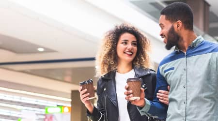 Couple Walking in Shopping Area with Coffee